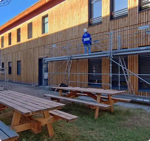 Artisans façadiers sur un échafaudage pour rénover un mur extérieur